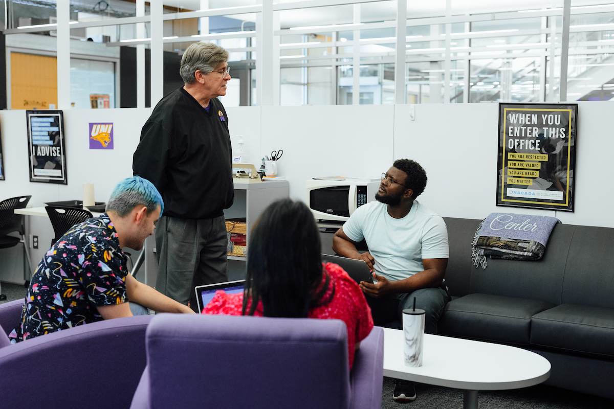 Academic advisor greets students in waiting room